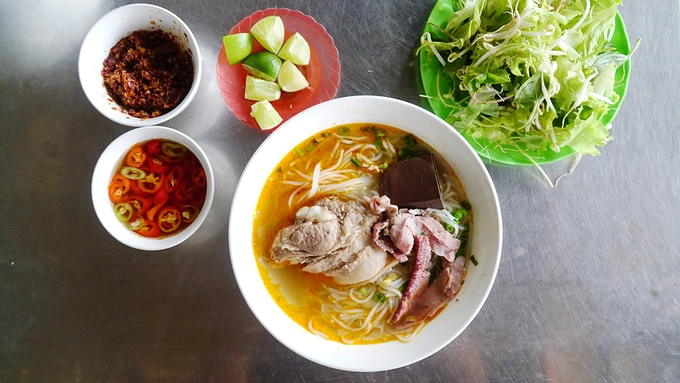 Bún bò Huế Khác với bún bò Huế thường thấy trong miền Nam, sợi bún ở Huế là loại cọng nhỏ, trắng tinh và mềm. Nước lèo có độ ngọt thanh, thơm nức. Món ăn còn níu chân nhiều người bởi vị cay xé lưỡi đã làm nên thương hiệu. Không chỉ nước dùng cay, trên bàn ăn luôn có nhiều loại ớt như: ớt băm, sa tế, ớt trái thái lát... cho thực khách nêm vào. Bạn có thể yêu cầu rau sống hoặc trụng theo khẩu vị. Ngày nay, bún bò có nhiều loại như: giò, chả, thịt ba chỉ... với giá trung bình khoảng 30.000 đồng/ tô. Bún bò Huế Khác với bún bò Huế thường thấy trong miền Nam, sợi bún ở Huế là loại cọng nhỏ, trắng tinh và mềm. Nước lèo có độ ngọt thanh, thơm nức. Món ăn còn níu chân nhiều người bởi vị cay xé lưỡi đã làm nên thương hiệu. Không chỉ nước dùng cay, trên bàn ăn luôn có nhiều loại ớt như: ớt băm, sa tế, ớt trái thái lát... cho thực khách nêm vào. Bạn có thể yêu cầu rau sống hoặc trụng theo khẩu vị. Ngày nay, bún bò có nhiều loại như: giò, chả, thịt ba chỉ... với giá trung bình khoảng 30.000 đồng/ tô.