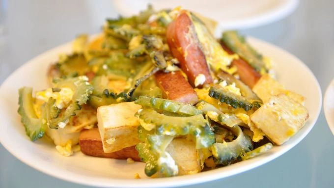 Goya champuru Nói đến ẩm thực Okinawa không thể không nhắc tới những món ăn nổi bật như goya champuru. Champuru, nghĩa là "trộn lẫn", một di sản ẩm thực của vùng. Món này gồm một số nguyên liệu, phổ biến nhất là có mướp đắng (goya), xào với đậu phụ, thịt heo và trứng. Món mướp này có thể làm theo nhiều cách, hoặc chiên như tempura hoặc thái mỏng và trộn trong salad hay với làm đồ muối để ăn kèm. Goya champuru Nói đến ẩm thực Okinawa không thể không nhắc tới những món ăn nổi bật như goya champuru. Champuru, nghĩa là "trộn lẫn", một di sản ẩm thực của vùng. Món này gồm một số nguyên liệu, phổ biến nhất là có mướp đắng (goya), xào với đậu phụ, thịt heo và trứng. Món mướp này có thể làm theo nhiều cách, hoặc chiên như tempura hoặc thái mỏng và trộn trong salad hay với làm đồ muối để ăn kèm.
