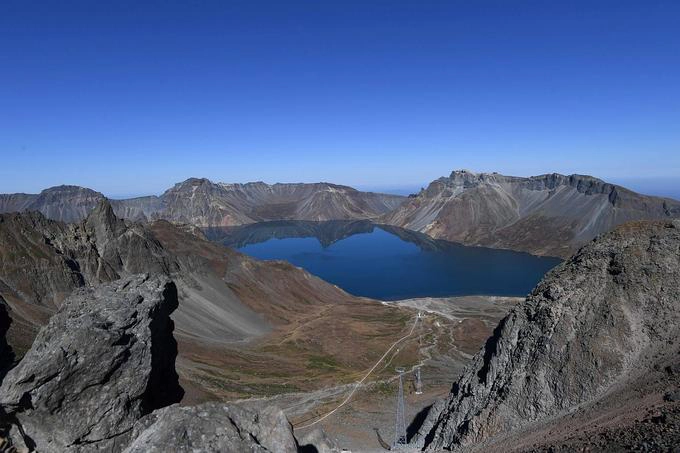 Vùng núi Paektu được cho là nơi các lãnh đạo Triều Tiên chào đời. Đây là đỉnh núi cao nhất bán đảo Triều Tiên với 2.744 m so với mực nước biển. Ngọn núi này cũng xuất hiện trong bức khảm phía sau tượng hai cố lãnh đạo của Triều Tiên (hình 1). Nhiều người Hàn Quốc thường xuyên lên núi Paektu, nhưng từ phía Trung Quốc. Moon Jae-in là tổng thống Hàn Quốc tại nhiệm đầu tiên tới thăm núi Paektu trên lãnh thổ Triều Tiên trong hội nghị liên Triều lần ba. Ảnh: Reuters.