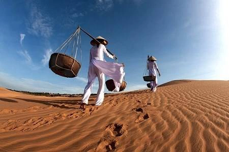 Du lịch Việt Nam - Hai cô gái ở Mũi Né, Phan Thiết mặc áo dài trắng và có đôi quang gánh trên vai xuất hiện trong khung cảnh tuyệt đẹp. Ảnh chụp của tác giả Ng Yeow Kee.