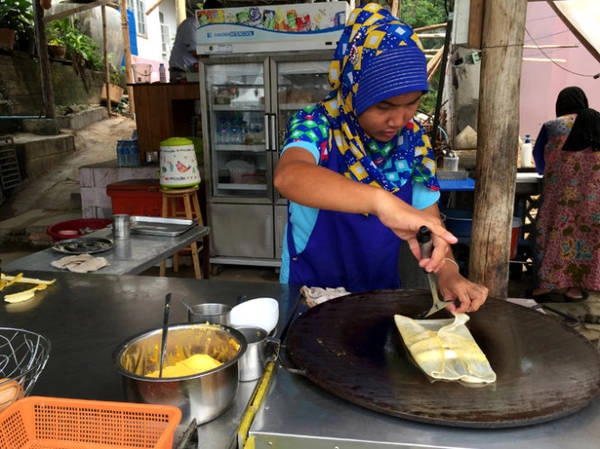 Một phụ nữ đạo Hồi làm món bánh Pancake chuối - Ảnh: Thủy OCG Một phụ nữ đạo Hồi làm món bánh Pancake chuối - Ảnh: Thủy OCG
