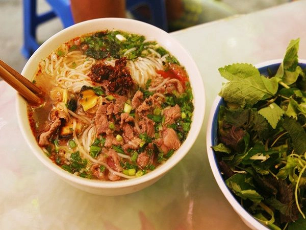Một tô gồm có bún, ốc và vài gia vị đi kèm như hành lá, cà chua, nhưng không vì vậy mà thiếu đi hương vị. Bù lại, nước dùng có phần chua hơn so với bún ốc khác nhưng vẫn rất vừa miệng. Ngoài ốc, khách cũng có thể gọi thêm thịt bò, hay giò để ăn kèm. Tùy theo khẩu vị, bạn có thể thêm chanh, sa tế,... Giá cho một tô bún ốc là 20.000 đồng, bún ốc có thêm thịt bò là 35.000 đồng. Ảnh: Phong Vinh. Một tô gồm có bún, ốc và vài gia vị đi kèm như hành lá, cà chua, nhưng không vì vậy mà thiếu đi hương vị. Bù lại, nước dùng có phần chua hơn so với bún ốc khác nhưng vẫn rất vừa miệng. Ngoài ốc, khách cũng có thể gọi thêm thịt bò, hay giò để ăn kèm. Tùy theo khẩu vị, bạn có thể thêm chanh, sa tế,... Giá cho một tô bún ốc là 20.000 đồng, bún ốc có thêm thịt bò là 35.000 đồng. Ảnh: Phong Vinh.