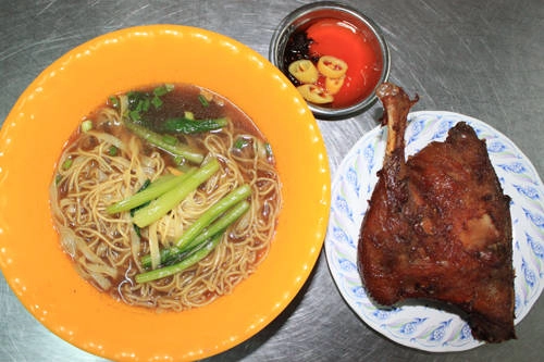 Chủ quán chia sẻ, để có được món ăn ngon, phần đùi và má đùi (gần một phần tư con vịt) được ướp thấm kỹ gia vị gia truyền, sau đó mang đi tiềm trong nước lèo có nhiều vị thuốc, cuối cùng miếng vịt được mang đi chiên rồi quay. Cách làm này khiến thịt vịt mềm trong khi phần da vừa giòn vừa thơm, ăn không bị ngán như cách tiềm thông thường. Ăn cùng vịt tiềm là mì vàng của người Hoa. Mì trứng trụng qua nước sôi cho vào tô cùng ít cọng cải luộc rồi chan nước tiềm vịt vào. Một phần ăn có giá từ 80.000 đồng. Ảnh: Huấn Phan. Chủ quán chia sẻ, để có được món ăn ngon, phần đùi và má đùi (gần một phần tư con vịt) được ướp thấm kỹ gia vị gia truyền, sau đó mang đi tiềm trong nước lèo có nhiều vị thuốc, cuối cùng miếng vịt được mang đi chiên rồi quay. Cách làm này khiến thịt vịt mềm trong khi phần da vừa giòn vừa thơm, ăn không bị ngán như cách tiềm thông thường. Ăn cùng vịt tiềm là mì vàng của người Hoa. Mì trứng trụng qua nước sôi cho vào tô cùng ít cọng cải luộc rồi chan nước tiềm vịt vào. Một phần ăn có giá từ 80.000 đồng. Ảnh: Huấn Phan.