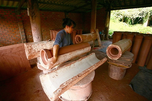 Xưởng còn chuyên làm ống thoát nước, sản phẩm này cũng có thể sử dụng làm ống khói. Chị Nguyễn Thị Thanh Tâm (ảnh), đã có 15 năm trong nghề. Đất được đưa vào hai nửa khuôn và ghép lại với nhau. Sau đó miết vết ghép nối. Độ dài đoạn ống được tính đủ cho tay thò vào thao tác ở hai đầu ống.