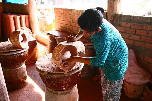 Một người thợ khác đang làm đoạn nối vuông góc của ống (được gọi là “cút”).