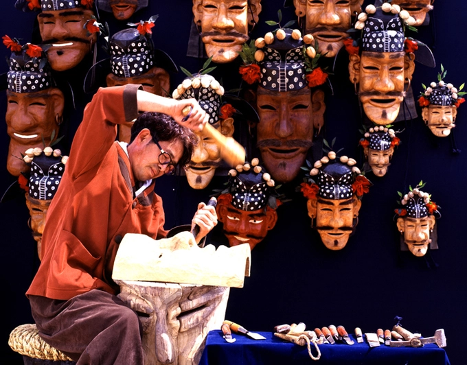 Theo truyền thuyết, thời kỳ Cao Ly ở Hàn Quốc, các vị thần ra lệnh cho thợ thủ công Huh Chongkak, dân làng Hahoe, phải tạo ra 12 chiếc mặt nạ gỗ khác nhau. Họ yêu cầu Chongkak không được gặp mặt ai cho đến khi hoàn tất công việc của mình. Đến khi người thợ này hoàn thành nửa trên của chiếc mặt nạ cuối cùng mang tên Imae - Kẻ Ngốc, một cô gái thầm yêu anh đã lén nhìn trộm. Ngay lập tức, Chongkak bị xuất huyết và chết, để lại chiếc mặt nạ cuối cùng không có hàm dưới. Ảnh: Antique Alive. Theo truyền thuyết, thời kỳ Cao Ly ở Hàn Quốc, các vị thần ra lệnh cho thợ thủ công Huh Chongkak, dân làng Hahoe, phải tạo ra 12 chiếc mặt nạ gỗ khác nhau. Họ yêu cầu Chongkak không được gặp mặt ai cho đến khi hoàn tất công việc của mình. Đến khi người thợ này hoàn thành nửa trên của chiếc mặt nạ cuối cùng mang tên Imae - Kẻ Ngốc, một cô gái thầm yêu anh đã lén nhìn trộm. Ngay lập tức, Chongkak bị xuất huyết và chết, để lại chiếc mặt nạ cuối cùng không có hàm dưới. Ảnh: Antique Alive.