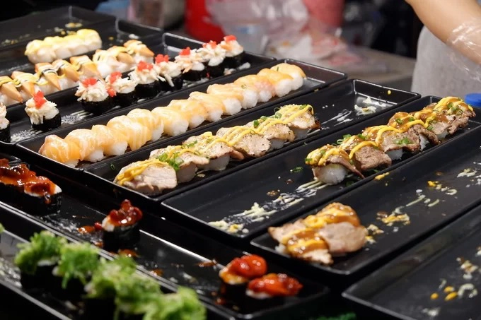 Cơm cuộn và sushi  Không chỉ có các món Thái, những khu chợ ẩm thực Chiang Mai còn bán kèm đồ ăn theo phong cách Nhật, Hàn. Bên cạnh cá, bạch tuộc, trứng tôm và xoài, các quầy hàng còn bán thêm sushi thịt nướng, sushi bò. Mỗi set giá từ 40 đến 90 baht (30.000 - 70.000 đồng) tùy loại nhân ăn kèm.