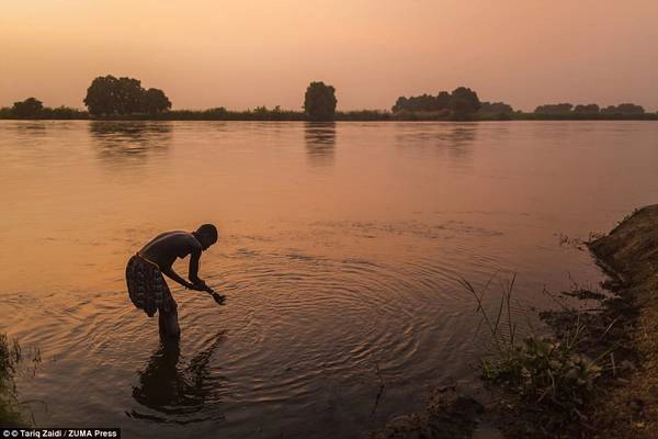 Một người phụ nữ của bộ tộc tắm ở sông Nile trong ánh hoàng hôn. Sau khi nội chiến kết thúc, hàng nghìn nam giới trở về Nam Sudan tìm vợ, khiến phụ nữ trở nên có giá. Một người phụ nữ của bộ tộc tắm ở sông Nile trong ánh hoàng hôn. Sau khi nội chiến kết thúc, hàng nghìn nam giới trở về Nam Sudan tìm vợ, khiến phụ nữ trở nên có giá.