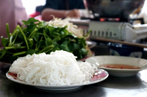 Bún tươi, rau sống để cho vào lẩu sẽ được dọn ra trước. Ngoài ra còn có một đĩa nước mắm ớt để chấm. Ảnh: Di Vỹ. Bún tươi, rau sống để cho vào lẩu sẽ được dọn ra trước. Ngoài ra còn có một đĩa nước mắm ớt để chấm. Ảnh: Di Vỹ.