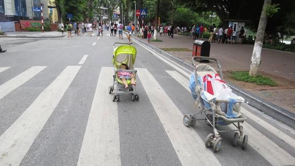 Một số phụ huynh còn an tâm để xe nôi của con giữa lòng đường. Một số phụ huynh còn an tâm để xe nôi của con giữa lòng đường.