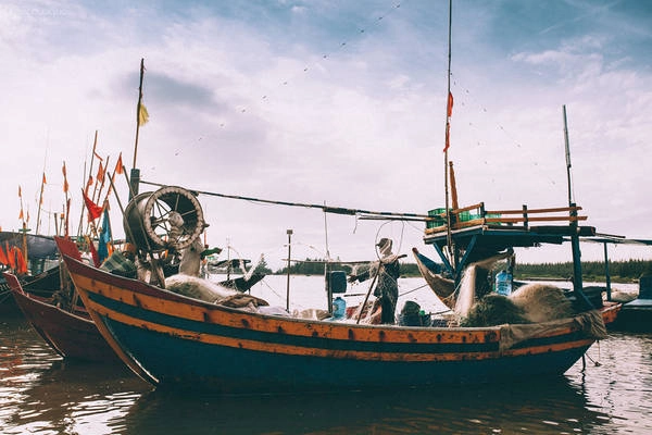 Ngư dân đang xếp lưới gọn gàng để chuẩn bị cho chuyến đánh bắt mới. Ai cũng vui vẻ và phối hợp nhịp nhàng với nhau trong công việc.