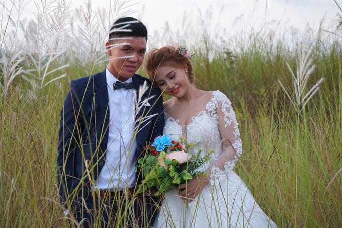 Một đôi bạn trẻ vẫn kiên nhẫn hoàn thành bộ ảnh cưới với hoa cỏ lau dù trời đã sẩm tối.