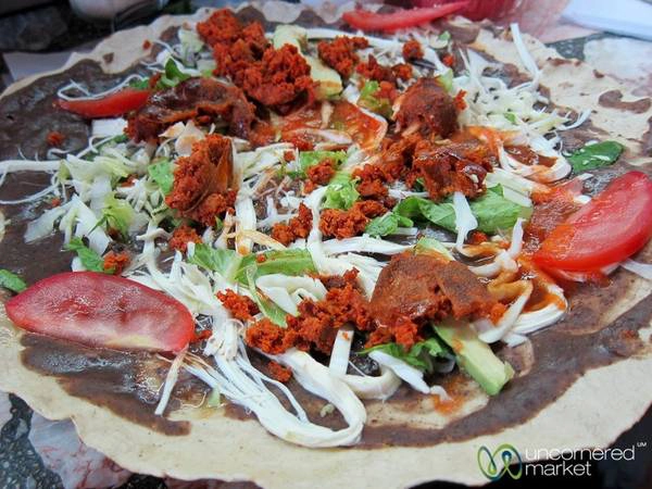 Mexico: Vùng Oaxaca của Mexico nổi tiếng với nền ẩm thực phong phú và độc đáo. Một trong các món ăn được nhiều du khách yêu thích là tlayuda - bánh mì dẹt với một lát thịt lợn thái mỏng, đậu chiên, khoai tây, bơ và một số loại thịt khác xé nhỏ. Ảnh: Uncornered Market. Mexico: Vùng Oaxaca của Mexico nổi tiếng với nền ẩm thực phong phú và độc đáo. Một trong các món ăn được nhiều du khách yêu thích là tlayuda - bánh mì dẹt với một lát thịt lợn thái mỏng, đậu chiên, khoai tây, bơ và một số loại thịt khác xé nhỏ. Ảnh: Uncornered Market.