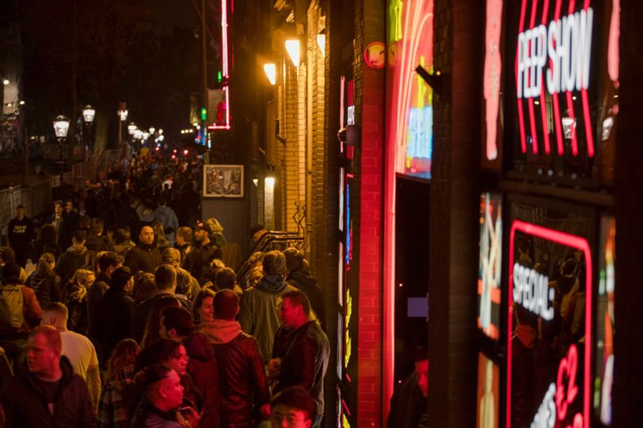 Khu phố đèn đỏ De Wallen thường thu hút khá đông du khách đi bộ vào ban đêm. Ảnh: AP.