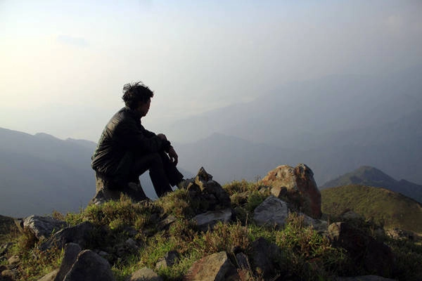 Anh chàng dẫn đường người Mông ngồi nghỉ trên tảng đá - Ảnh: Lê Hồng Thái