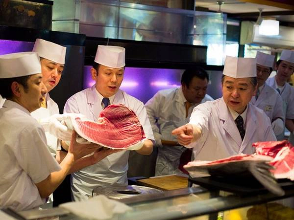 Chợ Tsukiji có khá nhiều hàng sushi tươi ngon và cũng là nơi cung cấp nguyên liệu cho nhiều nhà hàng cao cấp. Đầu bếp của chuỗi nhà hàng Sushi Zanmai đang xem xét một miếng cá ngừ mới cắt ngay ngoài chợ Tsukiji.