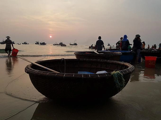 Thuyền thúng nghỉ ngơi sau khi hoàn thành việc chở hàng, trả lại bờ biển nhộn nhịp lúc sáng sớm bầu không khí yên bình để khách du lịch tản bộ, ngắm cảnh.  Đường đi: Từ trung tâm thành phố Tam Kỳ, bạn đi xe theo đường DT614 hướng ra biển Tam Thanh sẽ gặp một ngã ba. Từ đây đi thêm khoảng 6-7 km về phía tay phải sẽ đến chợ cá Tam Tiến.