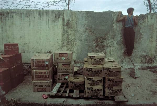 Một người đàn ông canh chừng cho lô hàng nhập lậu từ Trung Quốc, Móng Cái 1995.