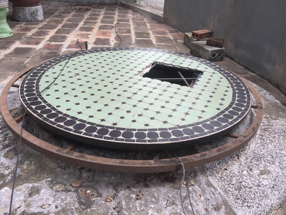 Phía thành giếng có một lớp sắt che đậy tránh người dân rơi xuống giếng