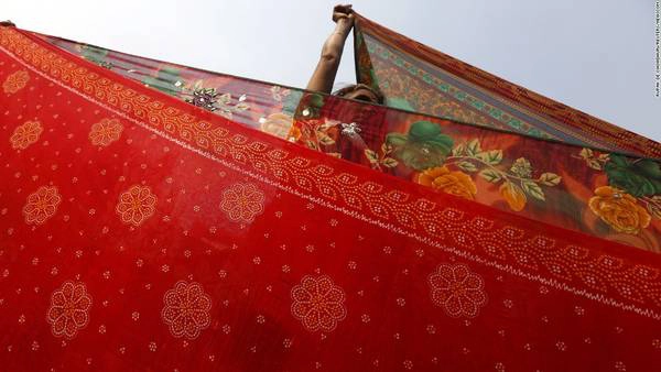 Kolkata, Ấn Độ: Một người phụ nữ đang phơi sari sau khi tham dự lễ tắm mình trong dòng sông Hằng ở đảo Sagar vào ngày 14/1. Sự kiện này là một phần của lễ hội Makar Sankranti, được tổ chức ở Ấn Độ, Nepal và Bangladesh.