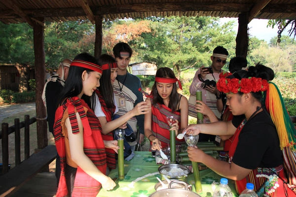 Du khách thử tài làm cơm ống tre. Những ống cơm này sau đó sẽ được phục vụ cho chính du khách vào bữa tối - Ảnh: Ngọc Đông