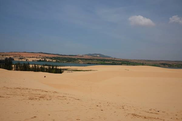 Điểm đầu tiên, xe đưa nhóm lên đồi cát trắng. Khác với đồi cát hồng, đồi cát Bàu Trắng rất đẹp, cát mịn và không có tình trạng xã rác như đồi cát hồng. Đứng trên cồn cát cao, bạn có thể nhìn thấy toàn cảnh “tiểu sa mạc Sahara” rộng lớn và hồ nước ngọt Bàu Trắng.