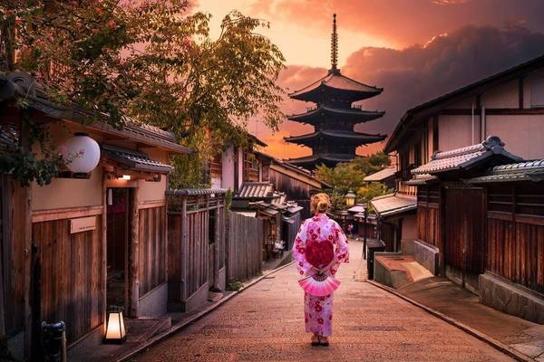 Người phụ nữ mặc kimono khoan thai dạo bước trên một con phố cổ kính ở Kyoto.