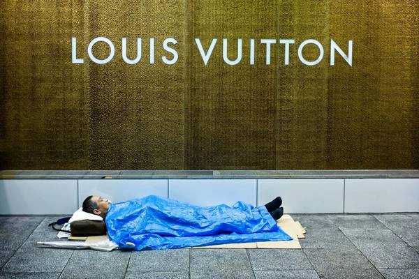 Bức ảnh người đàn ông nằm ngay ngắn dưới biển hiệu Louis Vuitton dấy lên tranh cãi liệu ông có phải là một người vô gia cư hay không.