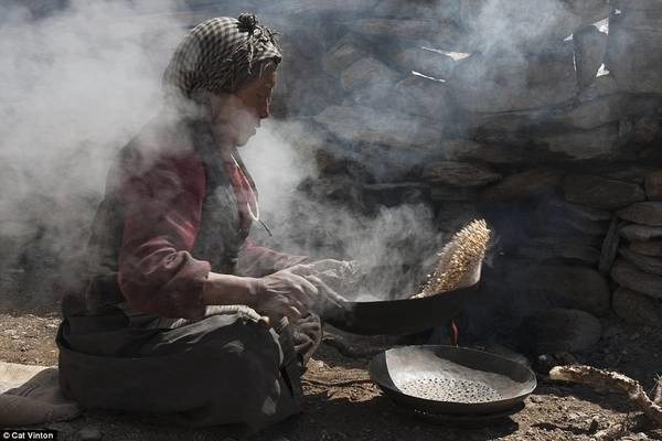 Bà Yangyen đang làm tsampa - một loại bột của Tây Tạng - từ đại mạch rang. Bà Yangyen đang làm tsampa - một loại bột của Tây Tạng - từ đại mạch rang.