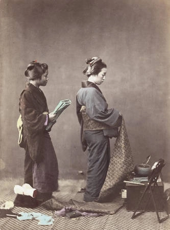 Một phụ nữ Nhật đang mặc kimono, quấn quanh eo bằng thắt lưng obi dài.