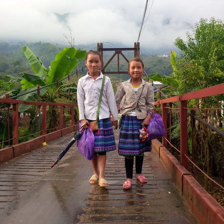 Hai em bé dân tộc đi dạo trên cầu ở Tả Van vào sáng sớm. Ảnh: Tùng Neo.