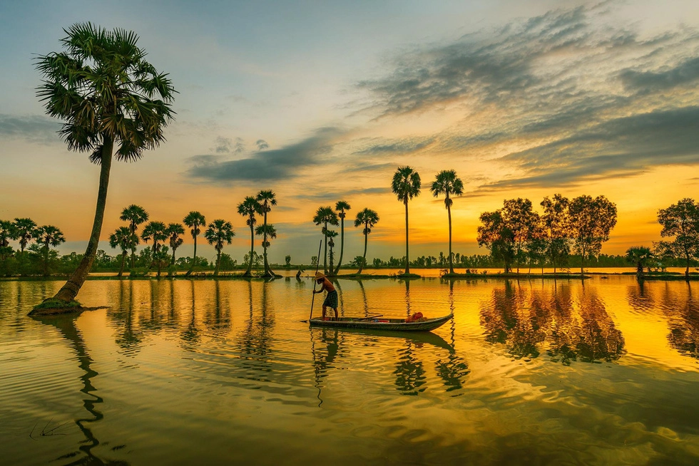 Một ngư dân đang chèo thuyền bắt cá tại cánh đồng ngập nước Tịnh Biên - Ảnh: MINH TRUNG Một ngư dân đang chèo thuyền bắt cá tại cánh đồng ngập nước Tịnh Biên - Ảnh: MINH TRUNG