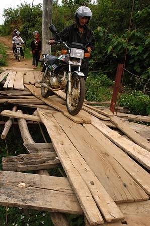 Muốn qua suối và mang theo phương tiện, không có cách nào khác là rón rén dắt từng đoạn như thế này. Ảnh: Tuổi Trẻ