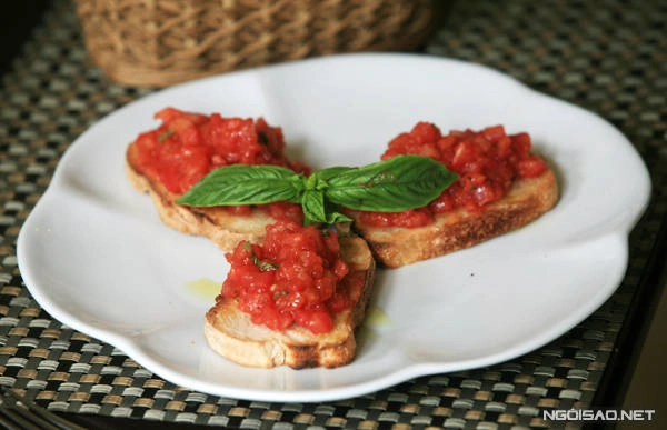 Món khai vị Bruschetta với bánh mỳ thái lát và sốt cà chua với dầu olive. Ảnh: Lê Bích Món khai vị Bruschetta với bánh mỳ thái lát và sốt cà chua với dầu olive. Ảnh: Lê Bích