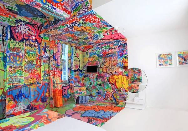 Với cách trang trí một nửa phòng là tranh Graffiti, nửa còn lại thì trắng muốt tạo cảm giác đầy nghệ thuật.