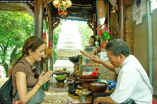 Một du khách Pháp đang được thầy cúng làm phép ở Wat Phnom. Ảnh: Trần Việt Anh