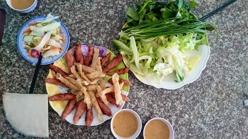 <strong>Nem nư​ớng: </strong> Cũng như bún bò Huế, nem nướng nổi tiếng tại Nha Trang nhưng nhiều người vẫn rủ nhau đi ăn món này ở quán Bà Hùng trên đường Phan Đình Phùng khi đến Đà Lạt. Khách đến quán chỉ cần ngồi xuống, trong tích tắc, món ăn sẽ được dọn ra. Giá ở đây là 40.000 đồng một phần, nem nướng ăn kèm rau sống tươi, cuốn bánh tráng và chấm nước mắm đậu phộng. Ảnh: Phạm Nhật Thắng