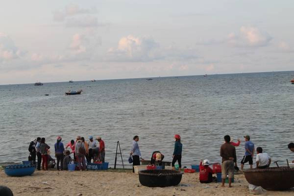 Người dân địa phương đang đợi thuyền đánh cá vào để thu mua hải sản. Ảnh: Khoa Trần