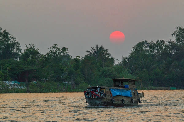 Hoàng hôn buông xuống trên dòng sông Hậu. Ảnh: Robert Muckley Hoàng hôn buông xuống trên dòng sông Hậu. Ảnh: Robert Muckley