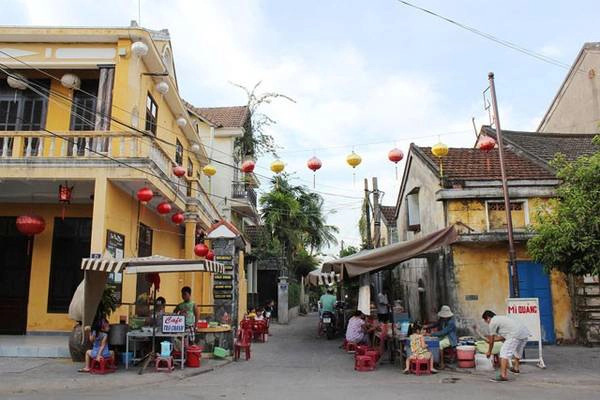 Bên trong cửa hàng là hình ảnh nghệ nhân đang định hình và tạo dáng cho đèn lồng.