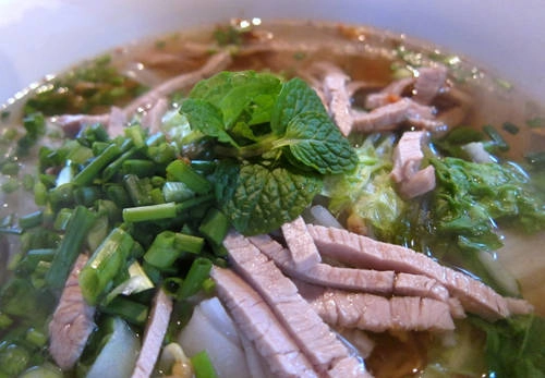 Mì Lào Một bát mì đơn giản với nước dùng, mì, các loại rau như húng quế, giá đỗ, bạc hà và ớt.