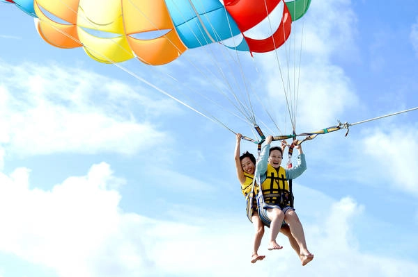 Ngày thứ 4 của hành trình, đoàn khảo sát du lịch đi thưởng ngoạn trò chơi dù lượn trên không. Khác với nhiều nơi bay dù thường cho khách "cất cánh" ngay tại bãi cát, tại đây từng nhóm khách được ca nô chở ra ngoài xa, cách bãi biển chừng 2 km để tham gia.