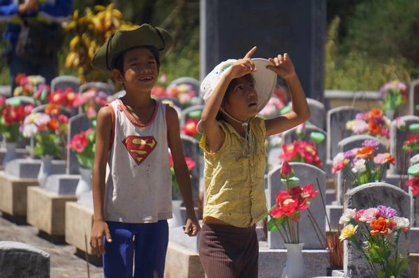 Những đứa trẻ mưu sinh bằng nghề bán nhang cho du khách ở nghĩa trang. Ảnh: Phan Lộc