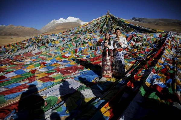 Một đôi vợ chồng đang chụp ảnh trong trang phục truyền thống của người Tây Tạng tại đèo Nianqing Tanggula. Ảnh: Damir Sagolj / Reuters