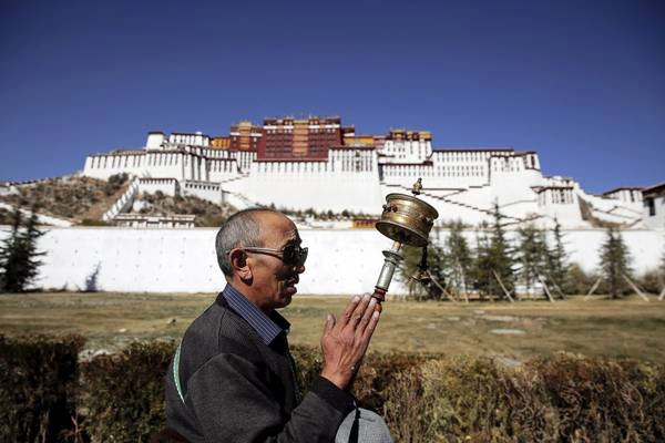 Một người đàn ông đang cầu nguyện trước Cung điện Potala. Cung điện này đã hơn 1.300 năm tuổi và từng là chốn tu hành của các vị Đạt Lai Lạt Ma tới đời thứ 14, tượng trưng cho Phật giáo Tây Tạng và đóng vai trò gìn giữ, truyền bá văn hóa truyền thống của Tây Tạng. Ảnh: Damir Sagolj / Reuters