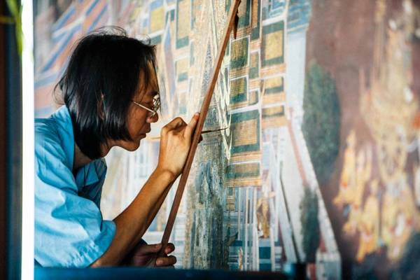 Một họa sĩ ở Grand Palace đang chăm chú với bức tranh của mình