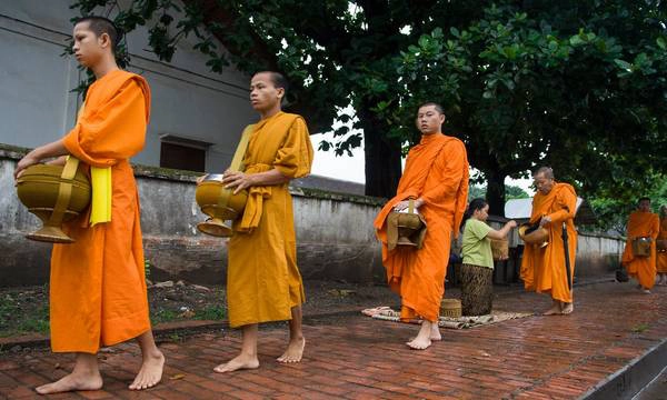 Các nhà sư đi khất thực vào buổi sáng tinh sương, tĩnh lặng và trầm mặc. Ảnh: Santiago Urquijo/Getty Images