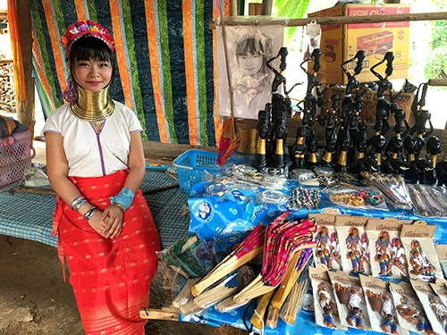 Làng cổ dài của người Karen phục vụ du lịch được tái dựng quanh một điểm du lịch với vé vào tham quan 500 baht. Quanh làng là các sạp hàng bán đồ thủ công như lụa và đồ lưu niệm nối tiếp nhau. Những cô gái Karen khi thấy khách đều ngồi nghiêm trang như sẵn sàng để khách chụp ảnh. Họ nói được rất ít tiếng Anh, chỉ là các câu giao tiếp đơn giản về giá cả. Trong làng chủ yếu là phụ nữ và trẻ em. Những em gái 6 tuổi đã bắt đầu đeo vòng cổ và ngồi bán hàng. Làng cổ dài của người Karen phục vụ du lịch được tái dựng quanh một điểm du lịch với vé vào tham quan 500 baht. Quanh làng là các sạp hàng bán đồ thủ công như lụa và đồ lưu niệm nối tiếp nhau. Những cô gái Karen khi thấy khách đều ngồi nghiêm trang như sẵn sàng để khách chụp ảnh. Họ nói được rất ít tiếng Anh, chỉ là các câu giao tiếp đơn giản về giá cả. Trong làng chủ yếu là phụ nữ và trẻ em. Những em gái 6 tuổi đã bắt đầu đeo vòng cổ và ngồi bán hàng.