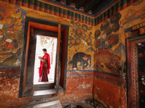 Nhà sư chỉnh sửa trang phục trước khi vào tu viện ở trung tâm Bhutan. Niềm tin Phật giáo có gốc rễ sâu xa là một trong những nhân tố chính để quốc gia này sử dụng GNP (tổng hạnh phúc quốc dân), thay cho GDP (tổng sản phẩm quốc nội) để đo độ thịnh vượng. Nhà sư chỉnh sửa trang phục trước khi vào tu viện ở trung tâm Bhutan. Niềm tin Phật giáo có gốc rễ sâu xa là một trong những nhân tố chính để quốc gia này sử dụng GNP (tổng hạnh phúc quốc dân), thay cho GDP (tổng sản phẩm quốc nội) để đo độ thịnh vượng.