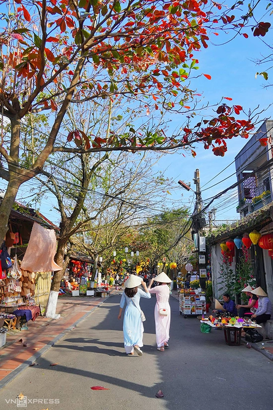 Hai phụ nữ trong tà áo dài khám phá nhịp sống Hội An trên đường Nguyễn Thị Minh Khai. Hội An có những con đường ngắn và hẹp, chạy dọc và ngang theo hình bàn cờ, cứ đi hết hẻm này là gặp hẻm khác.